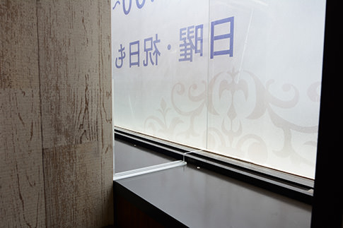 パーテーションと窓の隙間を塞ぐ透明なアクリル板の写真。